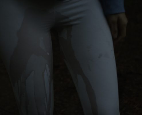 Close up of Sosha peeing in her leggings at night