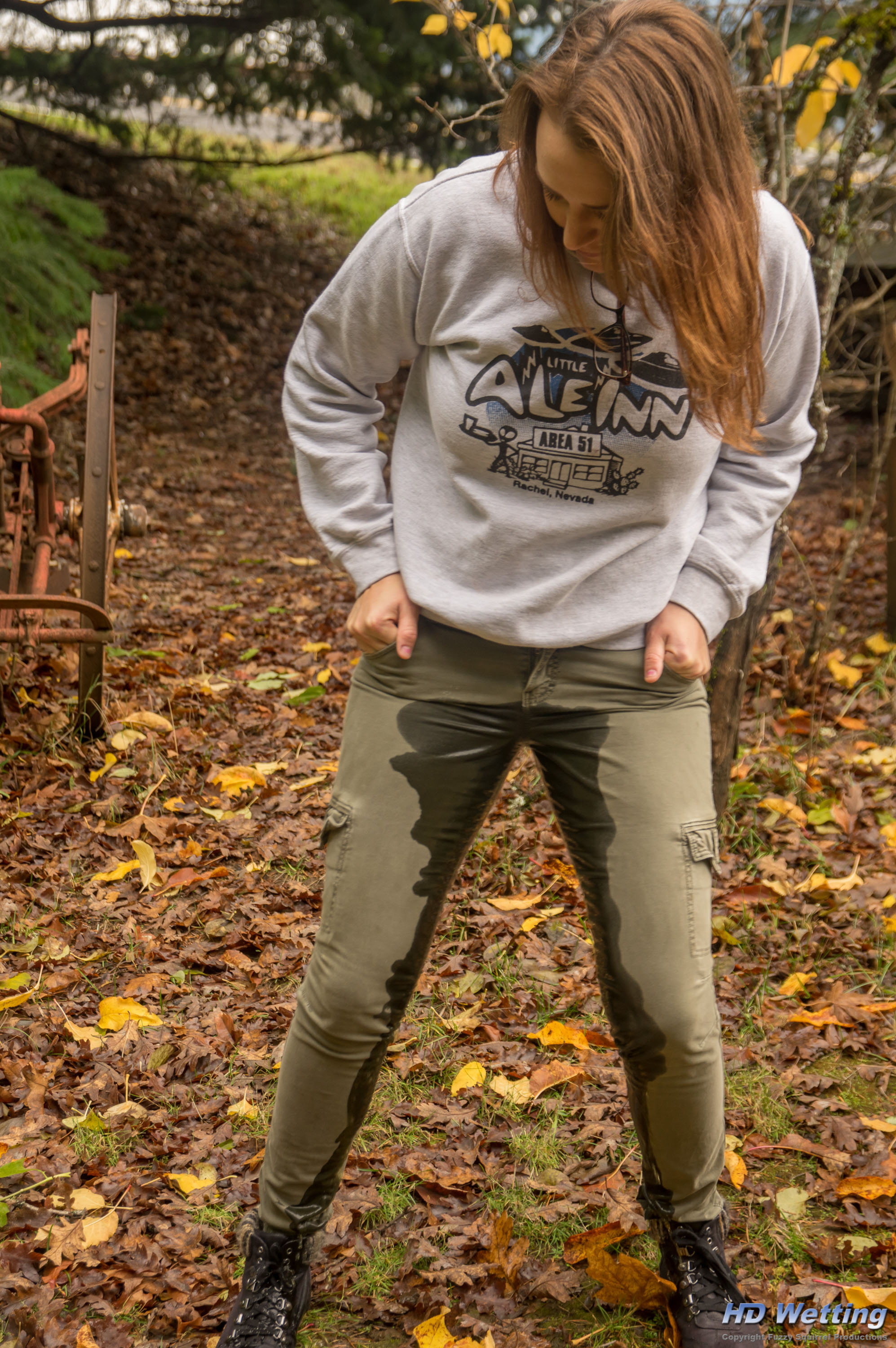 soaked-4529 A dark wet stain is visible running down the legs of her pants as she pees