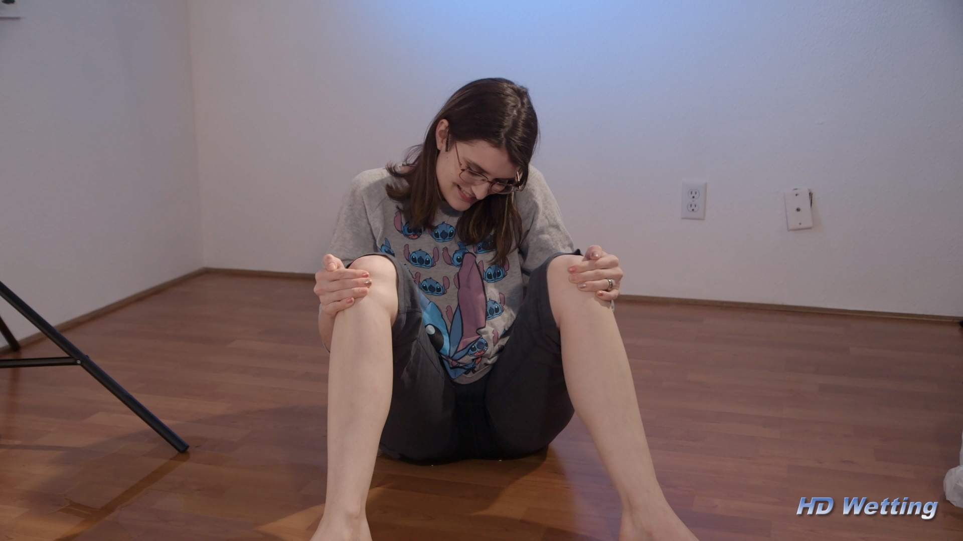 play-5 Sosha sitting on the floor in wet pants surrounded by the puddle she just made.