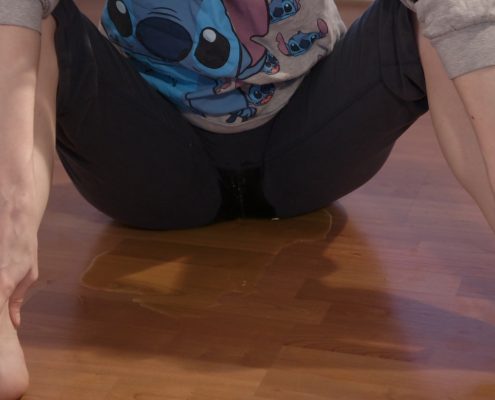Sitting on the floor, Sosha pees in her pants.