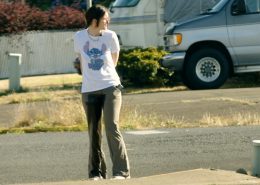 Standing along a city street in soaking wet pants.