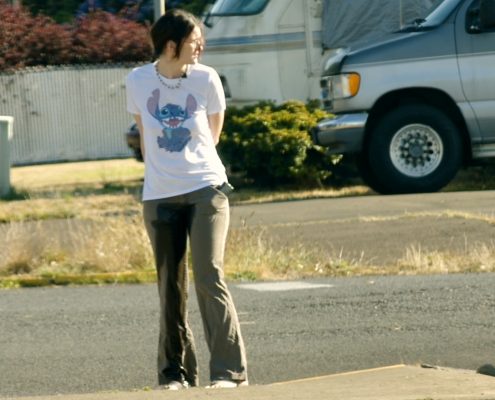 Standing along a city street in soaking wet pants.