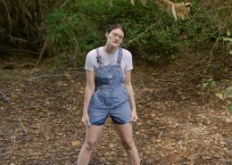 Peeing in her denim overalls.