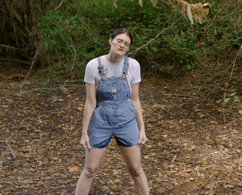 Peeing in her denim overalls.