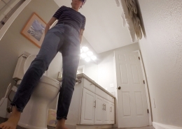 Standing in front of the toilet, Olivia's jeans are visibly wet.