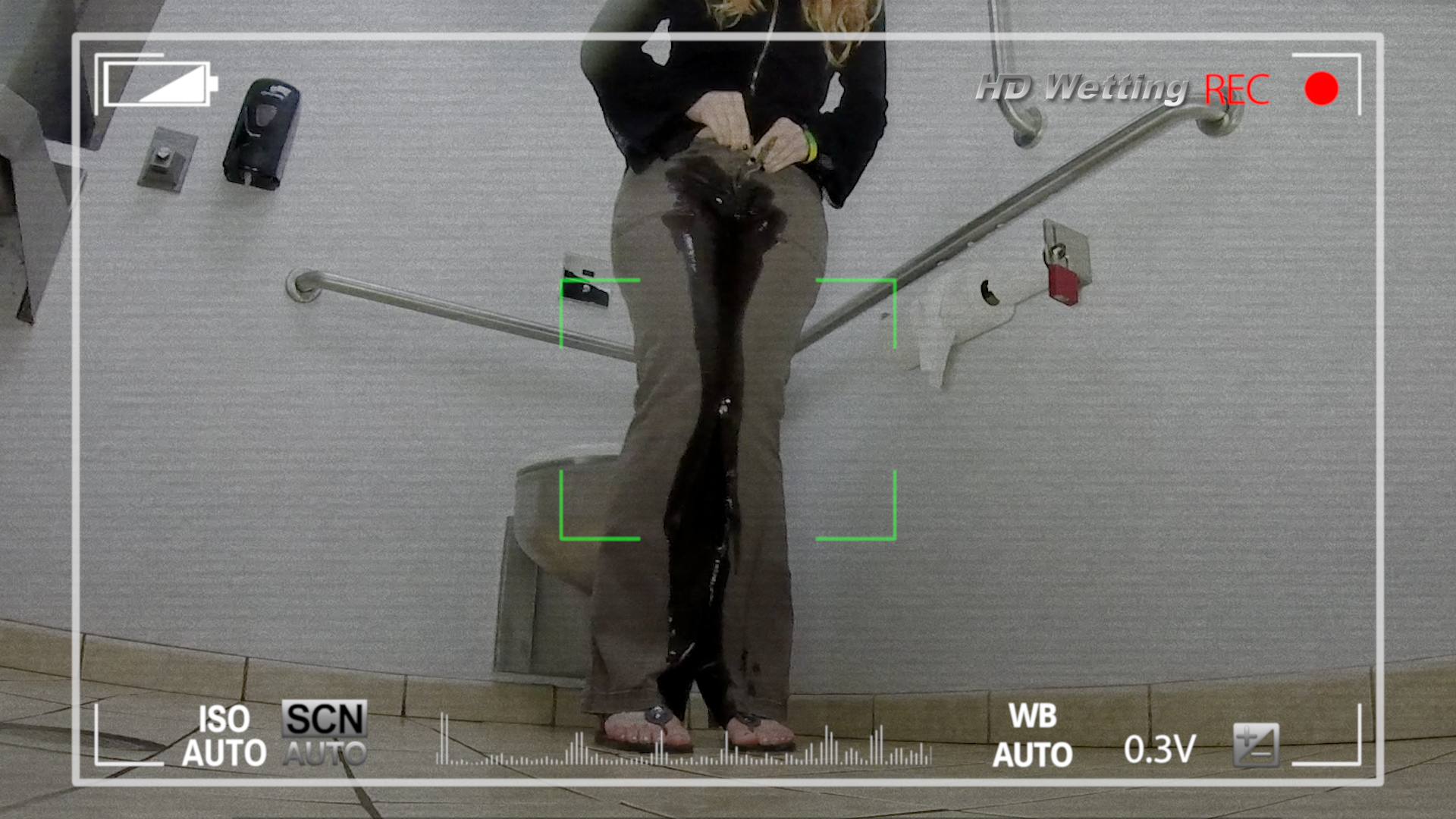 vid_901 View through a hidden camera in a public bathroom of a girl wetting her pants.