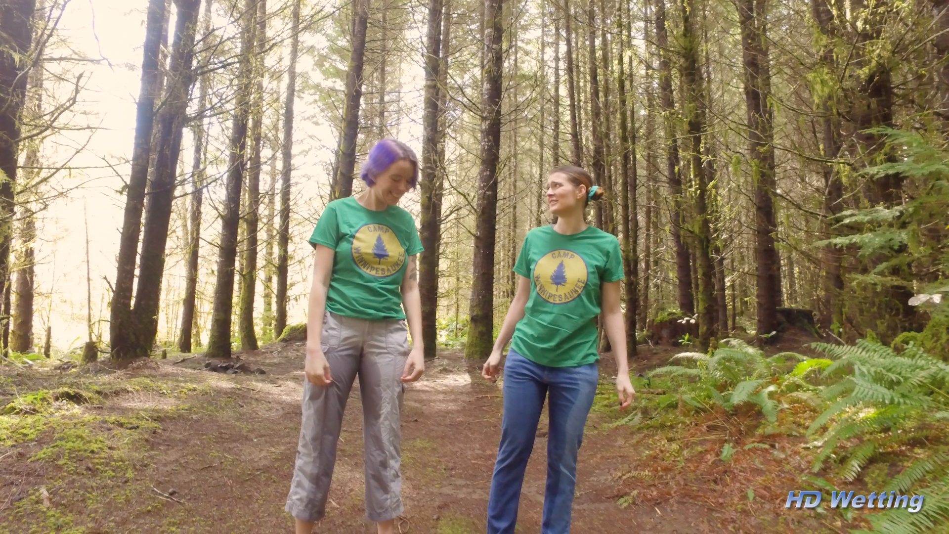 camp-10 Wide shot of Olivia and Sosha looking at one another's soaked pants.