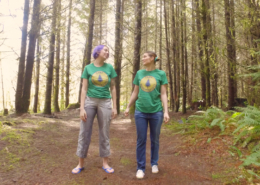 Oliva and Sosha both look at each other as they stand in the forest in their soaked pants.